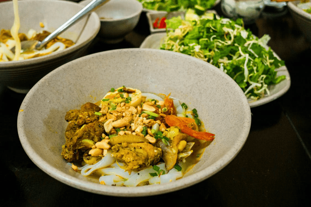 A flavorful bowl of Hoi An's iconic cao lau, where smoky pork meets crispy toppings and fresh herbs (Source: Pexels)